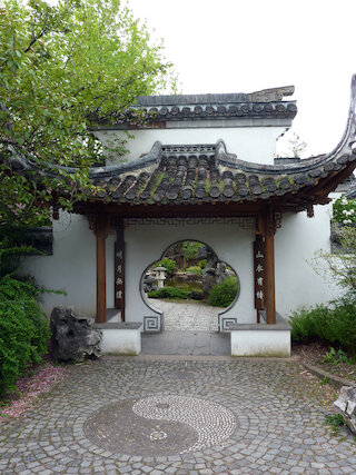 Das kieselsteingepflasterte Yin und Yang-Symbol am Garteneingang symbolisiert die Welt mit ihren Gegensätzen