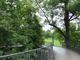 Die Seilnetzbrücke Lodzersteg für Fußgänger und Radfahrer zwischen den Baumwipeln hinunter in den Park